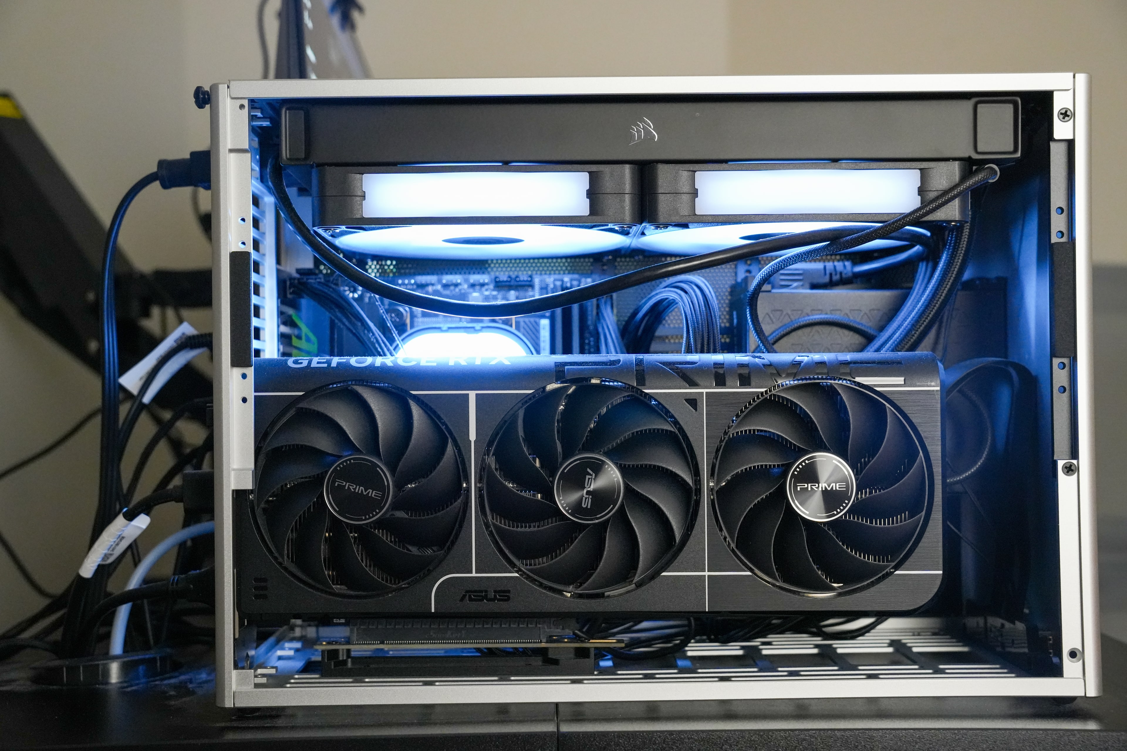 The build seen straight on, three graphics-card fans across the lower half and the radiator running the width of the frame above.
